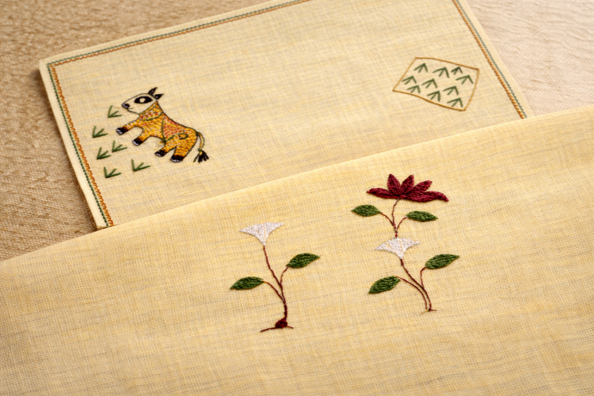 Comparison of Sujani and Chamba embroidery on textile, where Sujani’s narrative running stitch contrasts with Chamba’s structured floral needlework in Indian embroidery traditions.