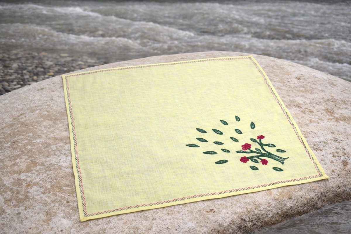 Sujani handkerchief on textile showing narrative embroidery formed through running stitch in Indian craft tradition.
