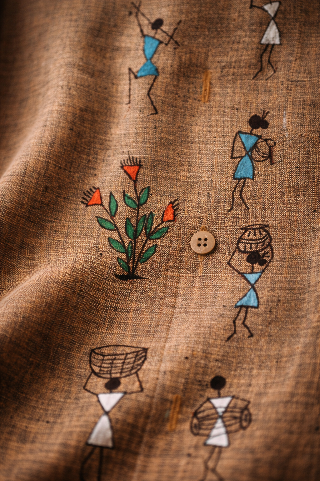 Hand-painted Warli art on linen fabric showing tribal figures, plant motif, and daily life scenes in traditional Indian geometric style