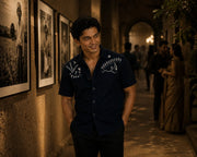 Young man wearing the Warli Aavartan hand-painted 100% linen half sleeve shirt in an exhibition gallery, illustrating how clothing shapes identity, perception, and personal presence.