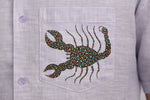 Load image into Gallery viewer, Close-up of hand-painted Bhil scorpion artwork on linen shirt pocket showing intricate dot work.