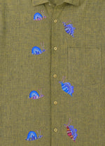 Load image into Gallery viewer, Bhil hand-painted linen shirt featuring seven snail artworks arranged across the front panel, photographed at the entrance of a limestone cave during an early morning exploration.