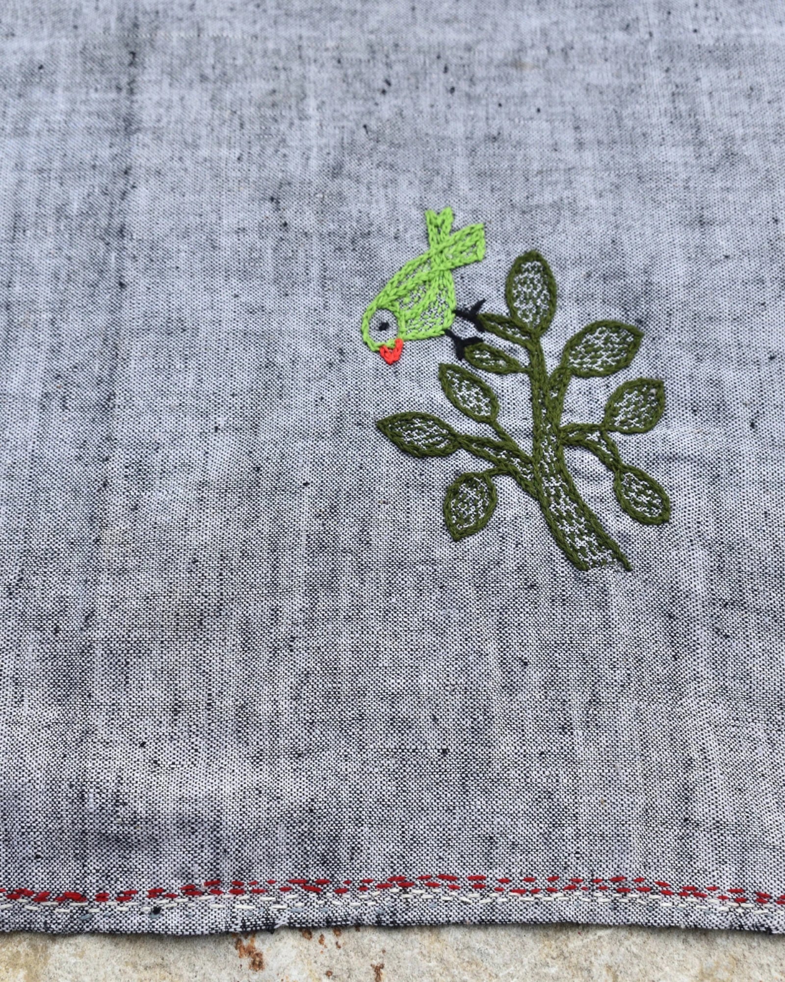 Close-up of a bird perched on a leafy tree artwork on a Bihar Sujani hand-embroidered khadi handkerchief.