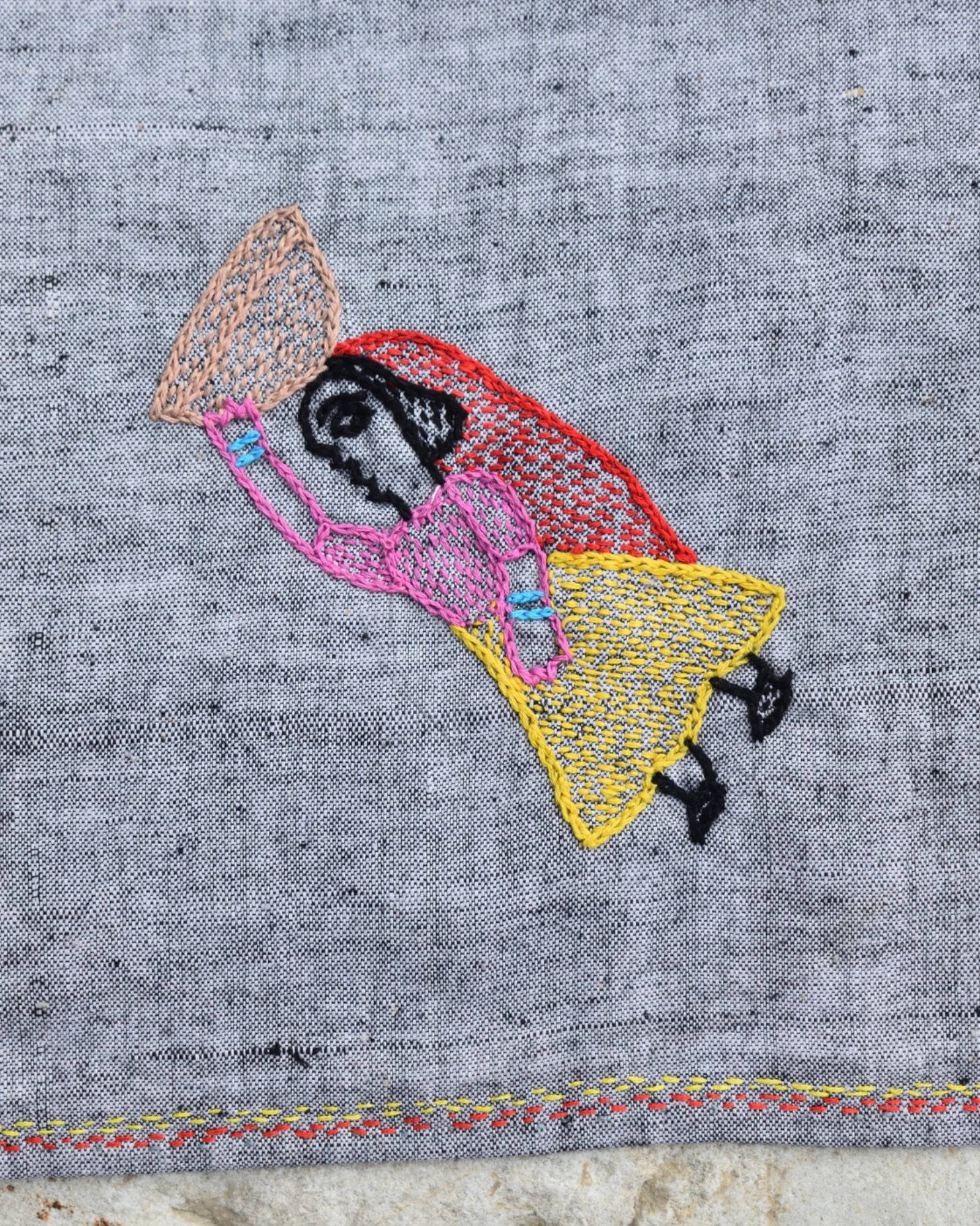 Close-up of the artwork showing a woman carrying a basket of food on a Bihar Sujani hand-embroidered khadi handkerchief.