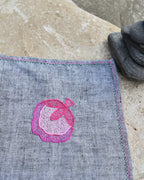 Close-up of hand-embroidered pink flower blossom artwork on a khadi cotton Bihar Sujani handkerchief, highlighting the floral embroidery and hand-finished border.