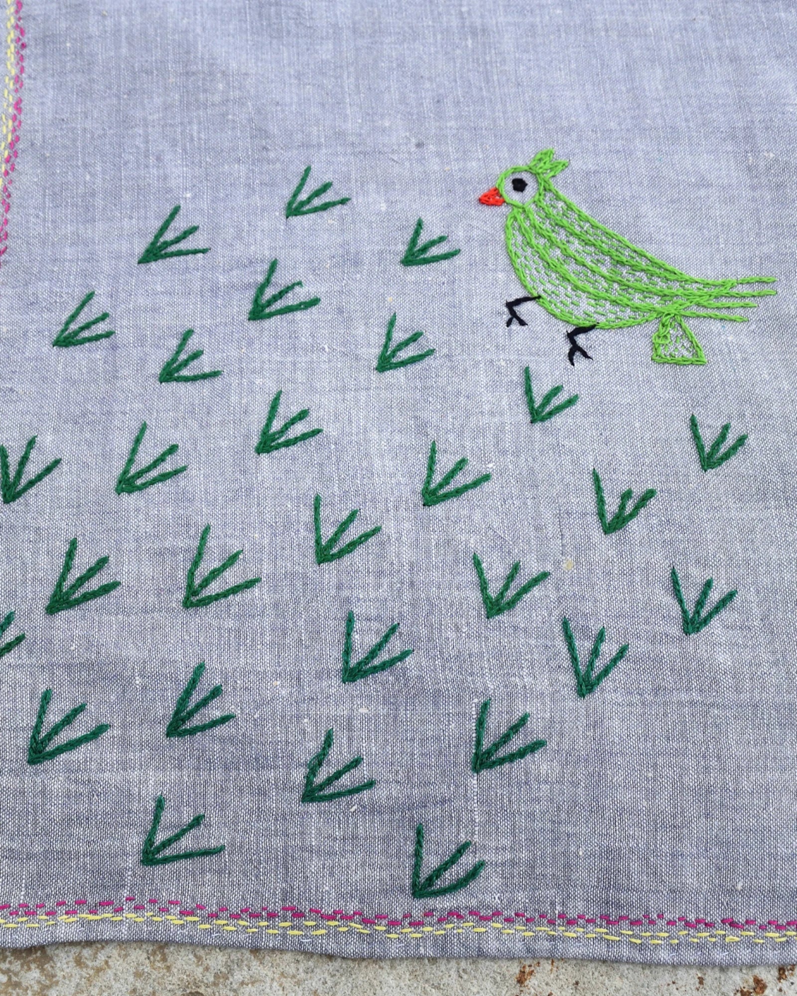 Close-up of the green parrot artwork on a hand-embroidered Bihar Sujani khadi cotton handkerchief.