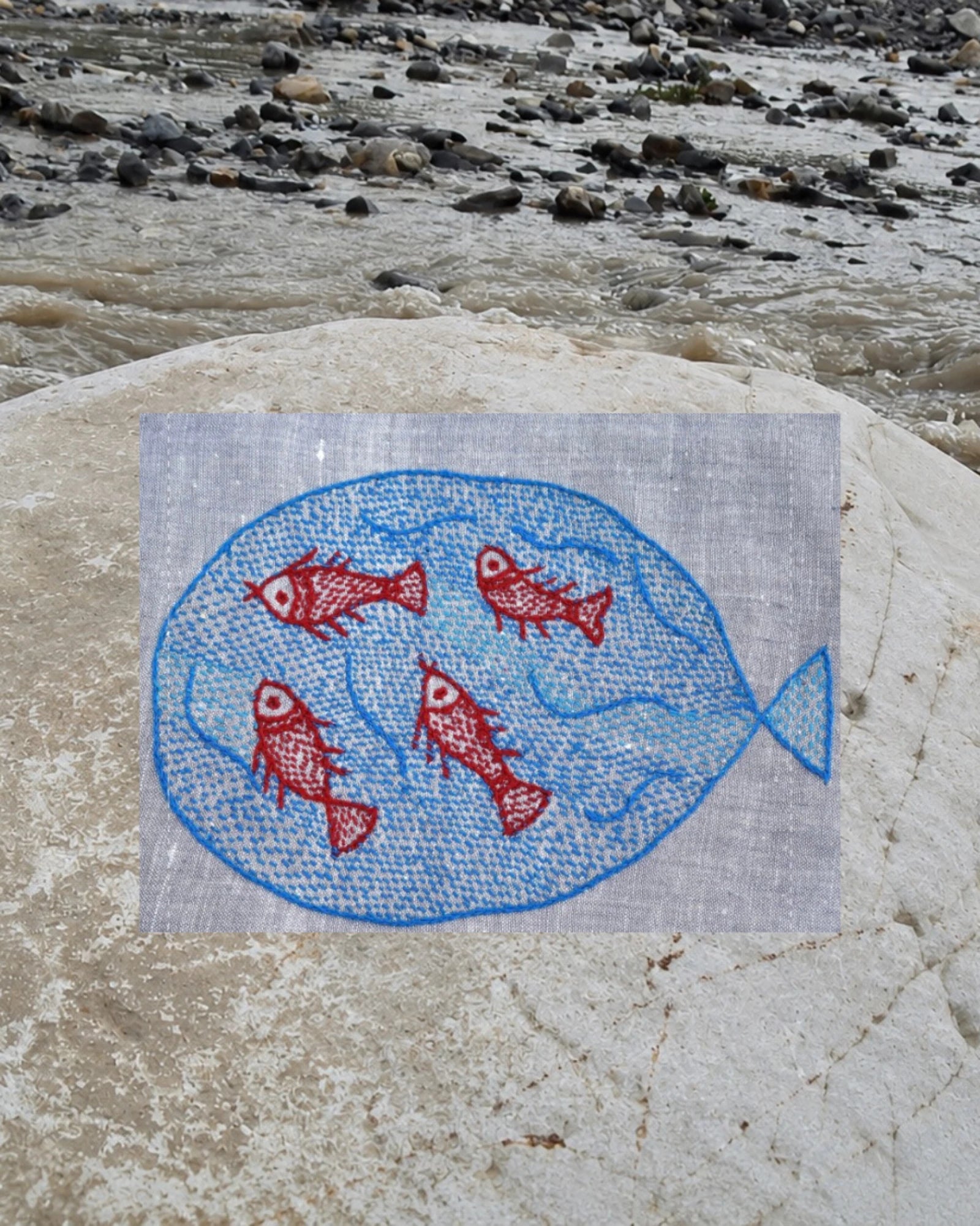 Close-up of a large blue fish artwork enclosing four red fish artworks on a Bihar Sujani hand-embroidered khadi handkerchief.