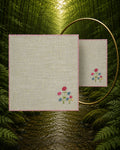 Chamba Rumal from the Pushp Vatika collection crafted in 100% linen, featuring hand embroidered blue and pink flowers with red hand hemming, photographed beside a mirror to display the traditional double-sided do-rukha embroidery.