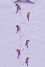 Gond hand-painted linen shirt featuring seven multicoloured bird motifs arranged vertically across both sides of the placket, shown in a close-up view highlighting hand-painted detailing and colour contrasts.