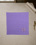 Kasuti Agumbe hand-embroidered khadi cotton handkerchief featuring a peacock motif in Murgi and Gavanti stitches, displayed on a pale stone conservation table.