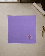 Kasuti Agumbe hand-embroidered khadi cotton handkerchief featuring a peacock motif in Murgi and Gavanti stitches, displayed on a pale stone conservation table.