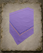Closer view of the Kodachadri handkerchief showing the Betel Box embroidery continuing around the corner in alternating deep blue and warm orange thread.