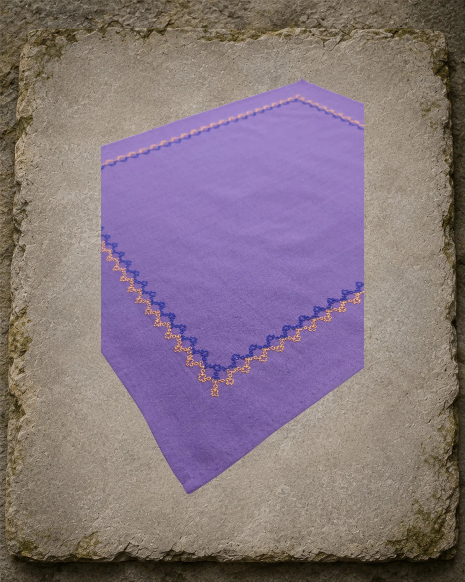 Closer view of the Kodachadri handkerchief showing the Betel Box embroidery continuing around the corner in alternating deep blue and warm orange thread.