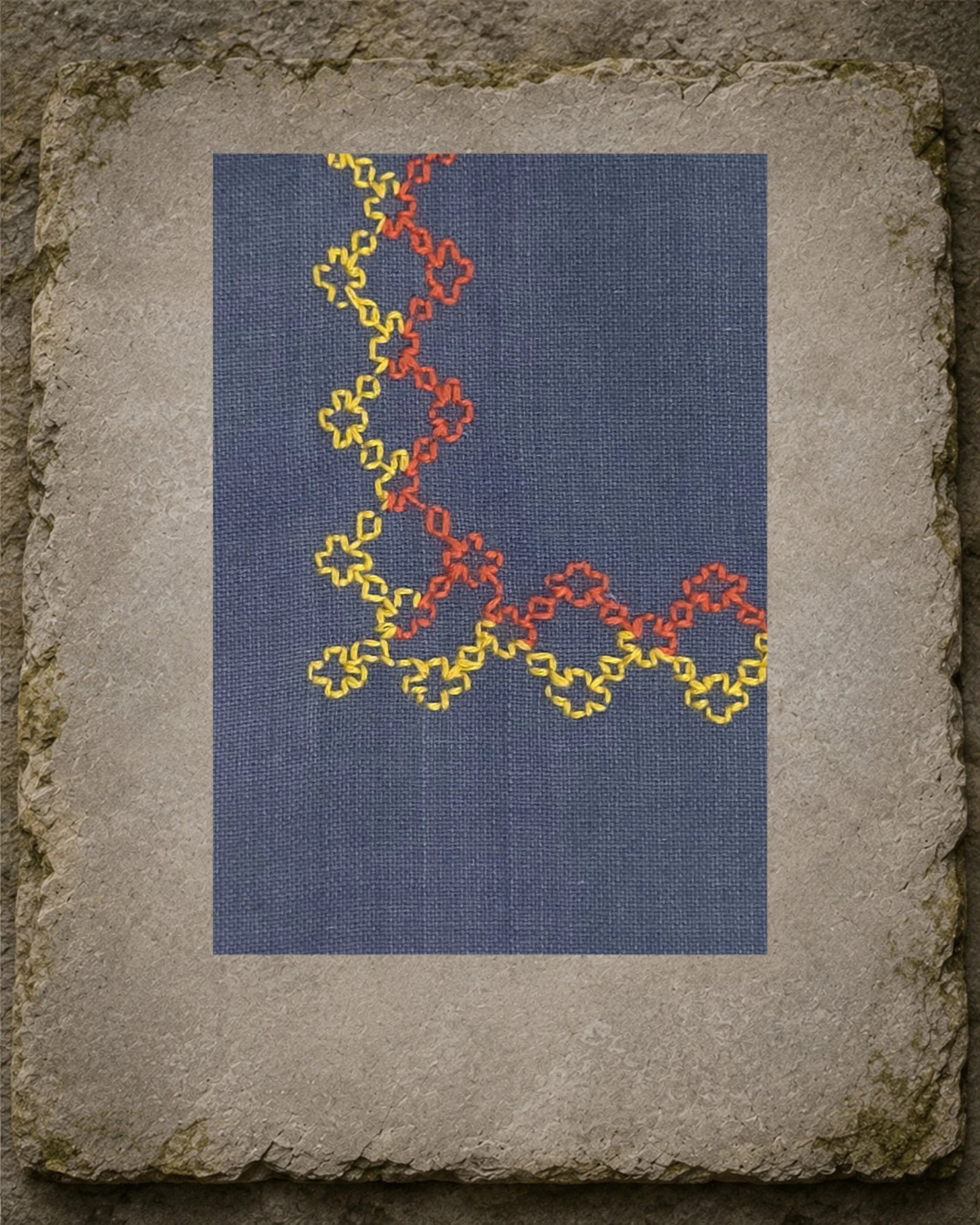 Detailed view of Kudremukh’s Kasuti border showing the counted Betel Box motifs worked by hand in yellow and orange thread against the visible khadi weave.
