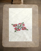Close view of the Mullayanagiri peacock motif, revealing Murgi and Gavanti stitches worked in deep pink, green and blue thread against the visible weave of the khadi cotton.