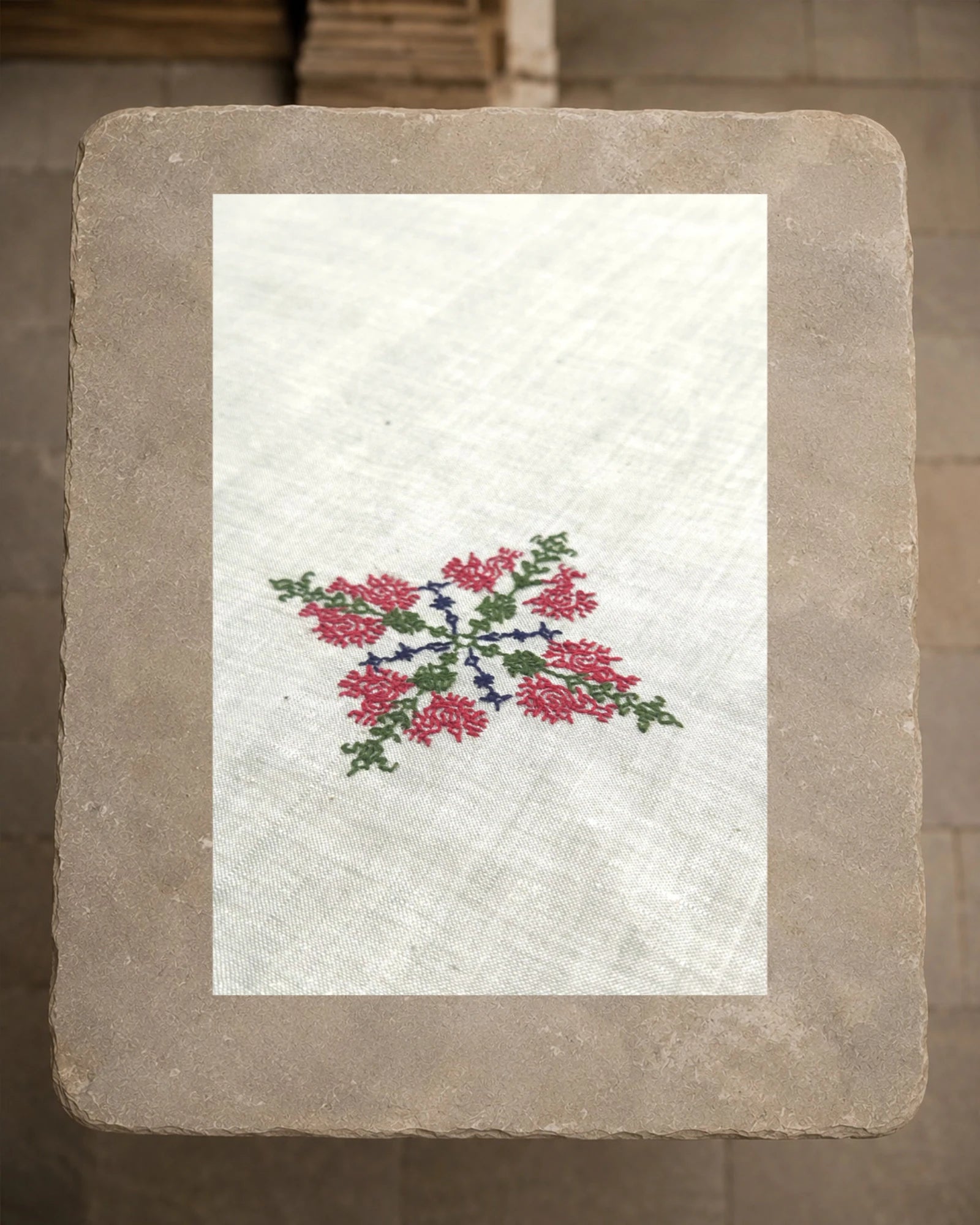 Close view of the Mullayanagiri peacock motif, revealing Murgi and Gavanti stitches worked in deep pink, green and blue thread against the visible weave of the khadi cotton.