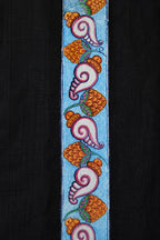 Close-up of hand-painted Odisha Pattachitra detailing running vertically along the placket of a linen shirt, showing repeating conch forms, floral elements, and fine painted linework.