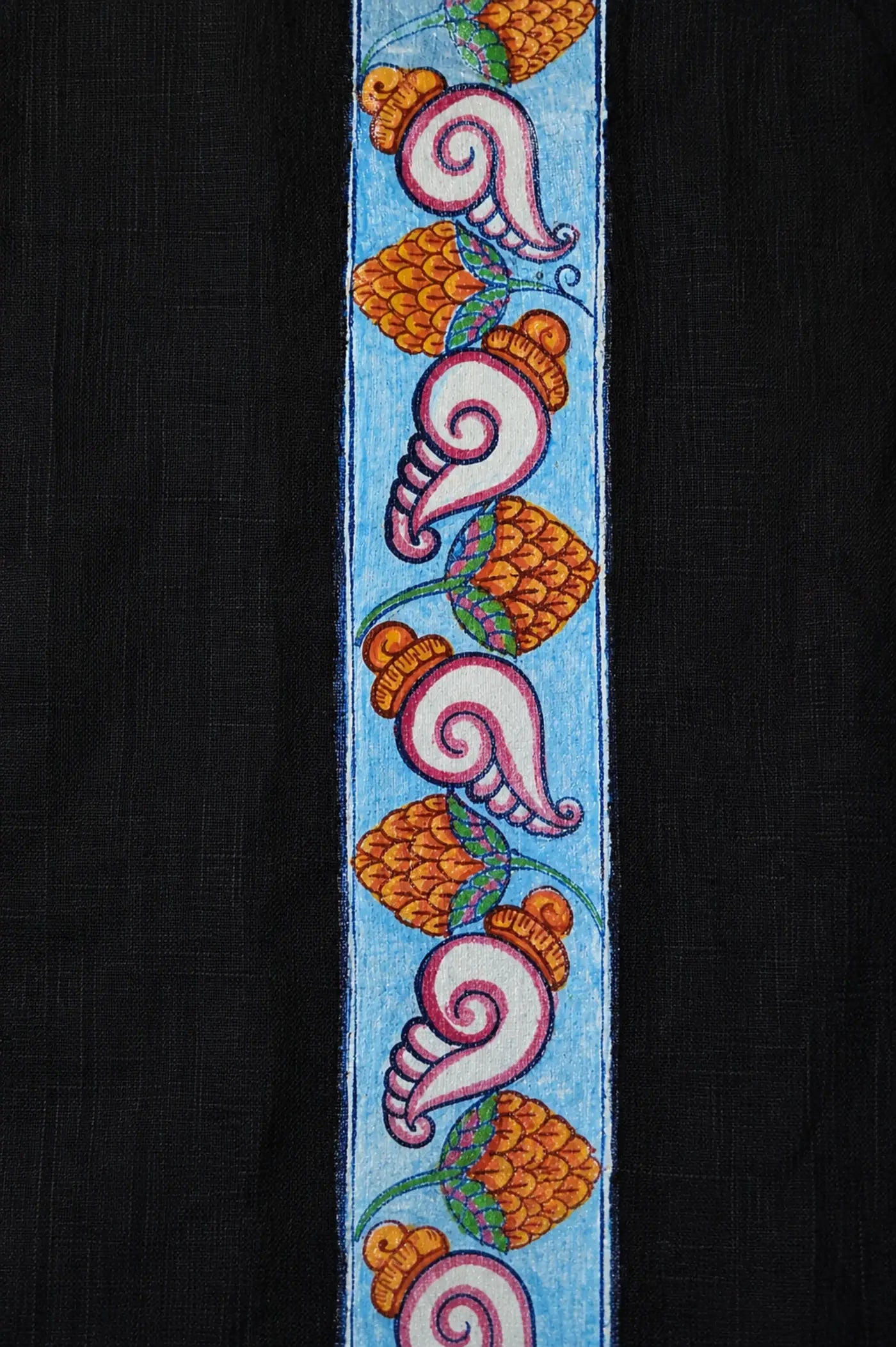 Close-up of hand-painted Odisha Pattachitra detailing running vertically along the placket of a linen shirt, showing repeating conch forms, floral elements, and fine painted linework.