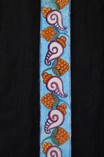 Load image into Gallery viewer, Close-up of hand-painted Odisha Pattachitra detailing running vertically along the placket of a linen shirt, showing repeating conch forms, floral elements, and fine painted linework.