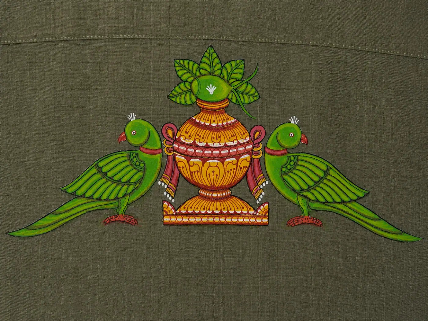 Close-up of hand-painted Odisha Pattachitra back motif on linen shirt, showing twin parrot forms, ceremonial kalash detailing, pigment variation, and textile weave.