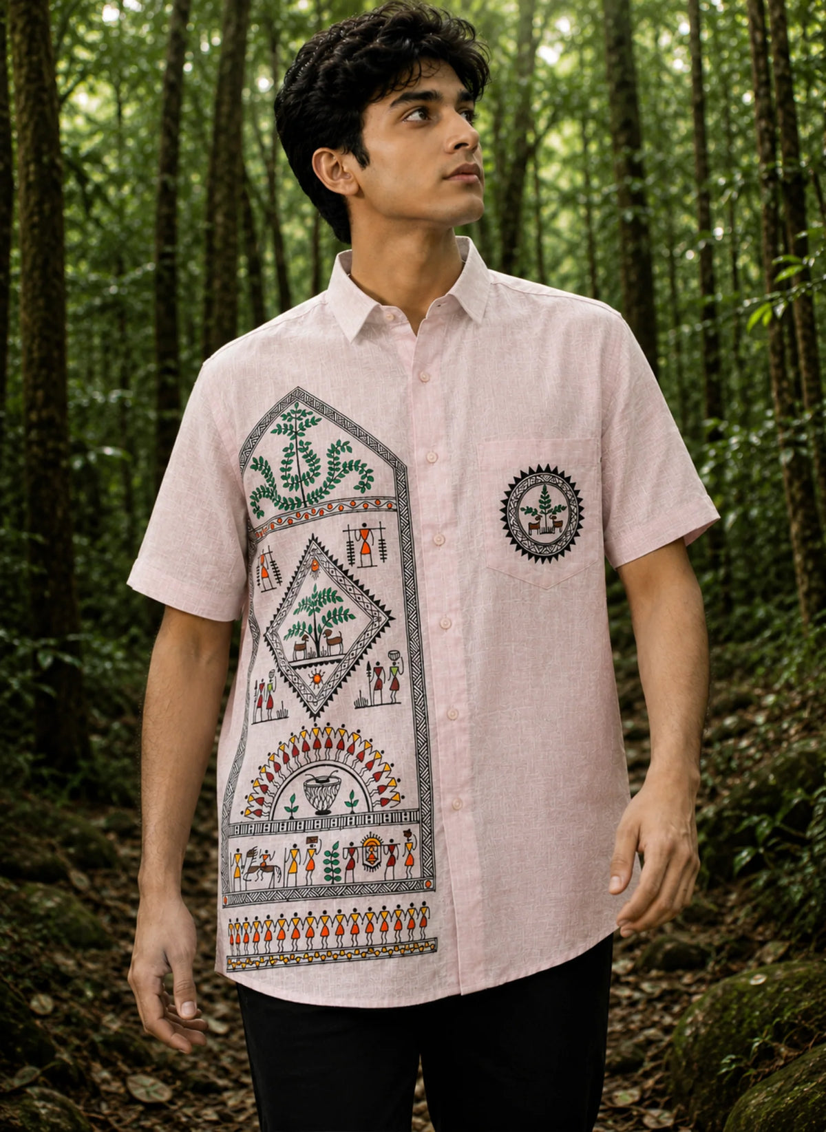 Saura Eneb hand-painted linen shirt featuring trees, animals and scenes of community life, photographed in a dense forest.