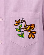 Sohrai Aikya linen shirt pocket close-up featuring hand-painted bird and vegetation artwork.