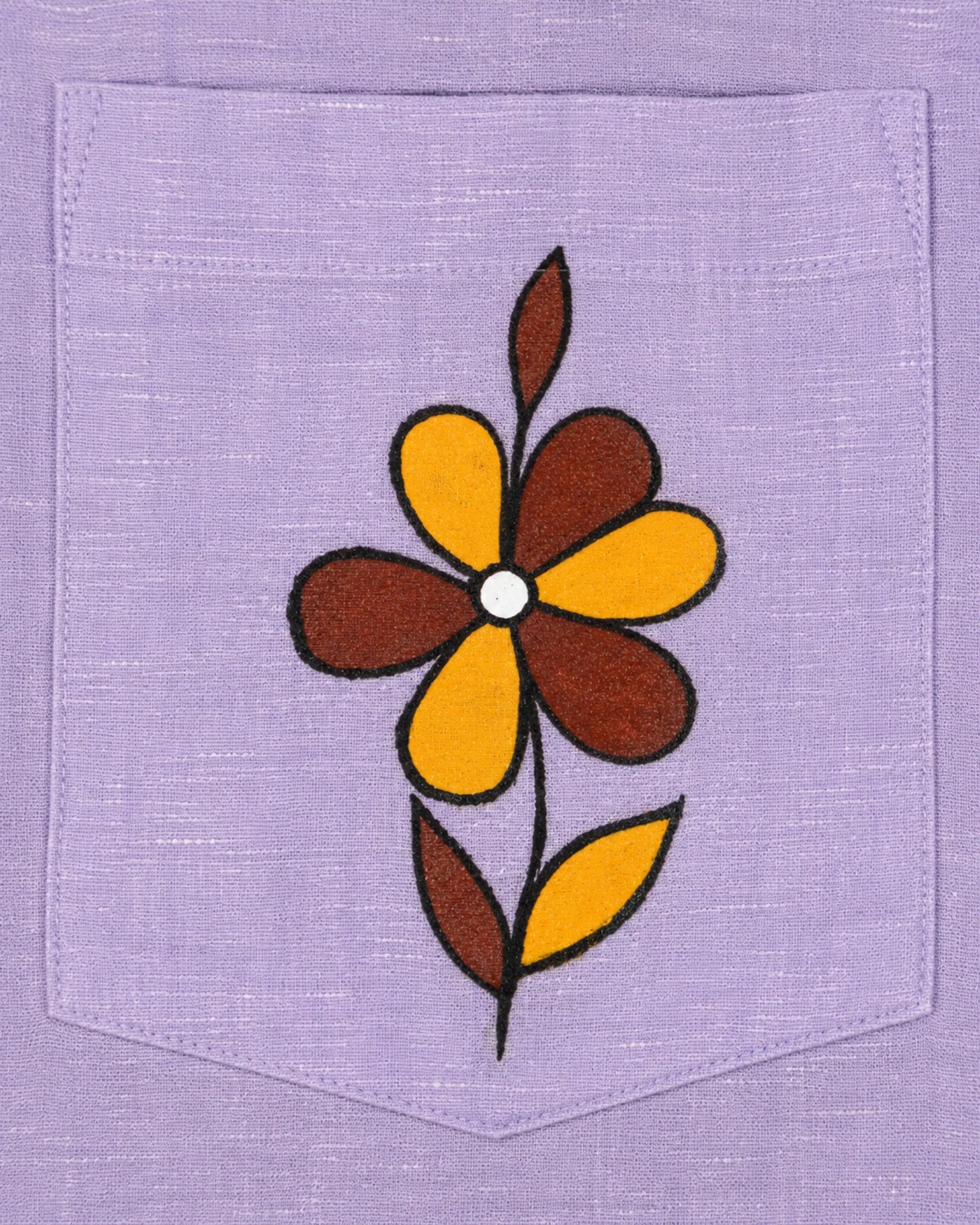 Sohrai Jar linen shirt pocket close-up featuring a hand-painted six-petal flower in ochre yellow and rust brown with a stem and leaves.