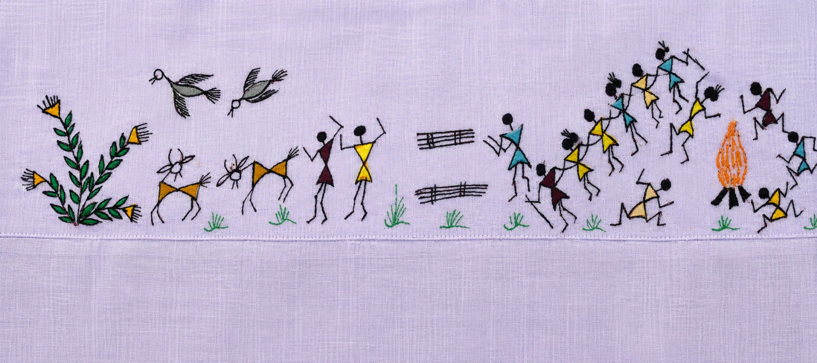 Close-up of the back artwork on the Warli Aabha hand-painted linen shirt, featuring a flowering plant, two birds in flight, goats, enjoying figures, wood stocks, a procession of warli tarpa dance, and a gathering around a ceremonial fire arranged across the upper back yoke in a continuous Warli composition.