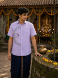 Warli Utsav hand-painted linen shirt featuring a curved Tarpa dance composition surrounding a central Tarpa musician across the front panel, observed beside an ancestral stone well during Ganesh Chaturthi preparations, with marigold decorations, a brass lota, and a softly blurred family setting in the background.