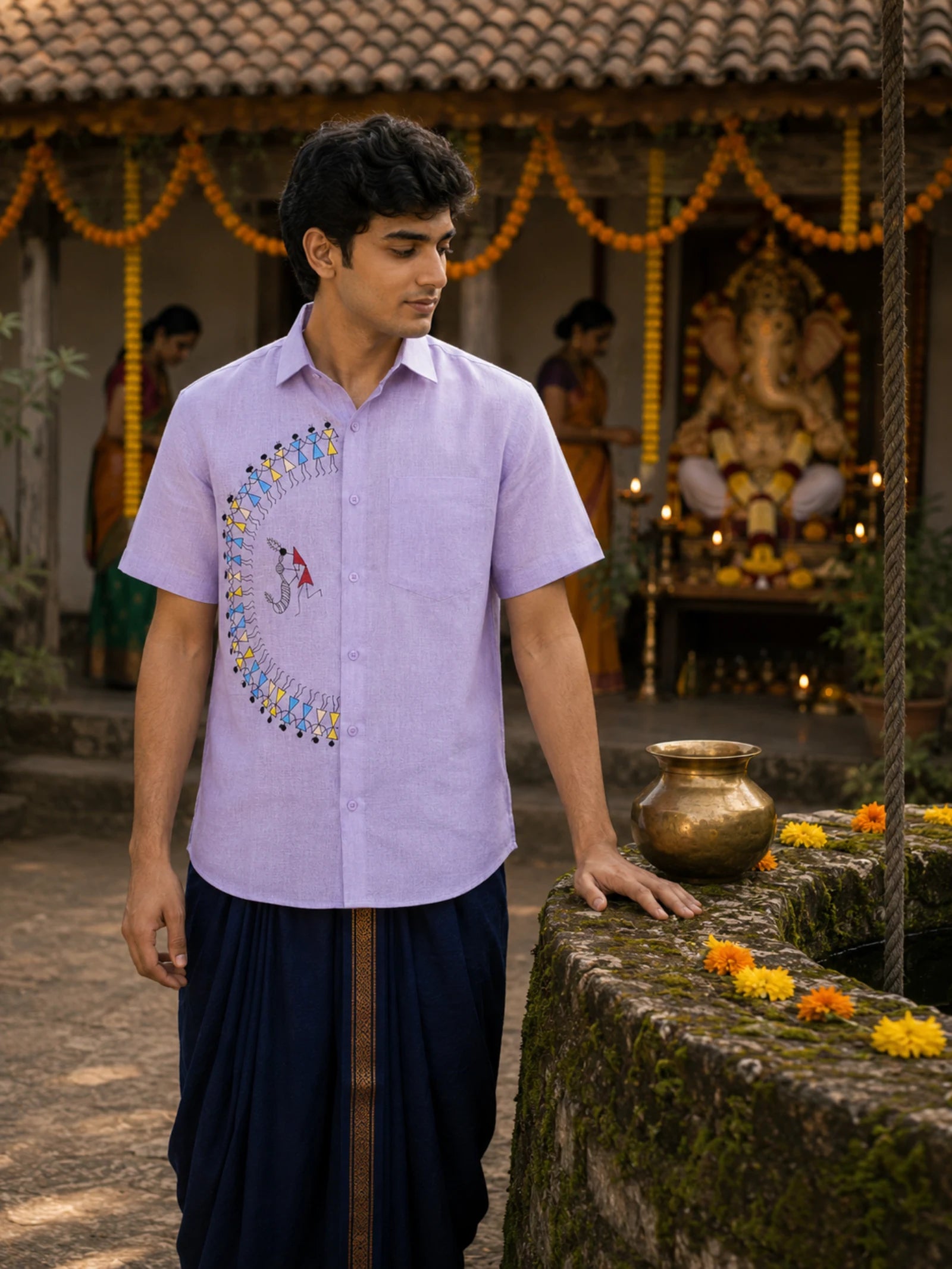 Warli Utsav hand-painted linen shirt featuring a curved Tarpa dance composition surrounding a central Tarpa musician across the front panel, observed beside an ancestral stone well during Ganesh Chaturthi preparations, with marigold decorations, a brass lota, and a softly blurred family setting in the background.