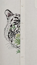 Close-up of tiger artwork crossing the front placket of the Padchinh hand-painted linen shirt on natural linen fabric.