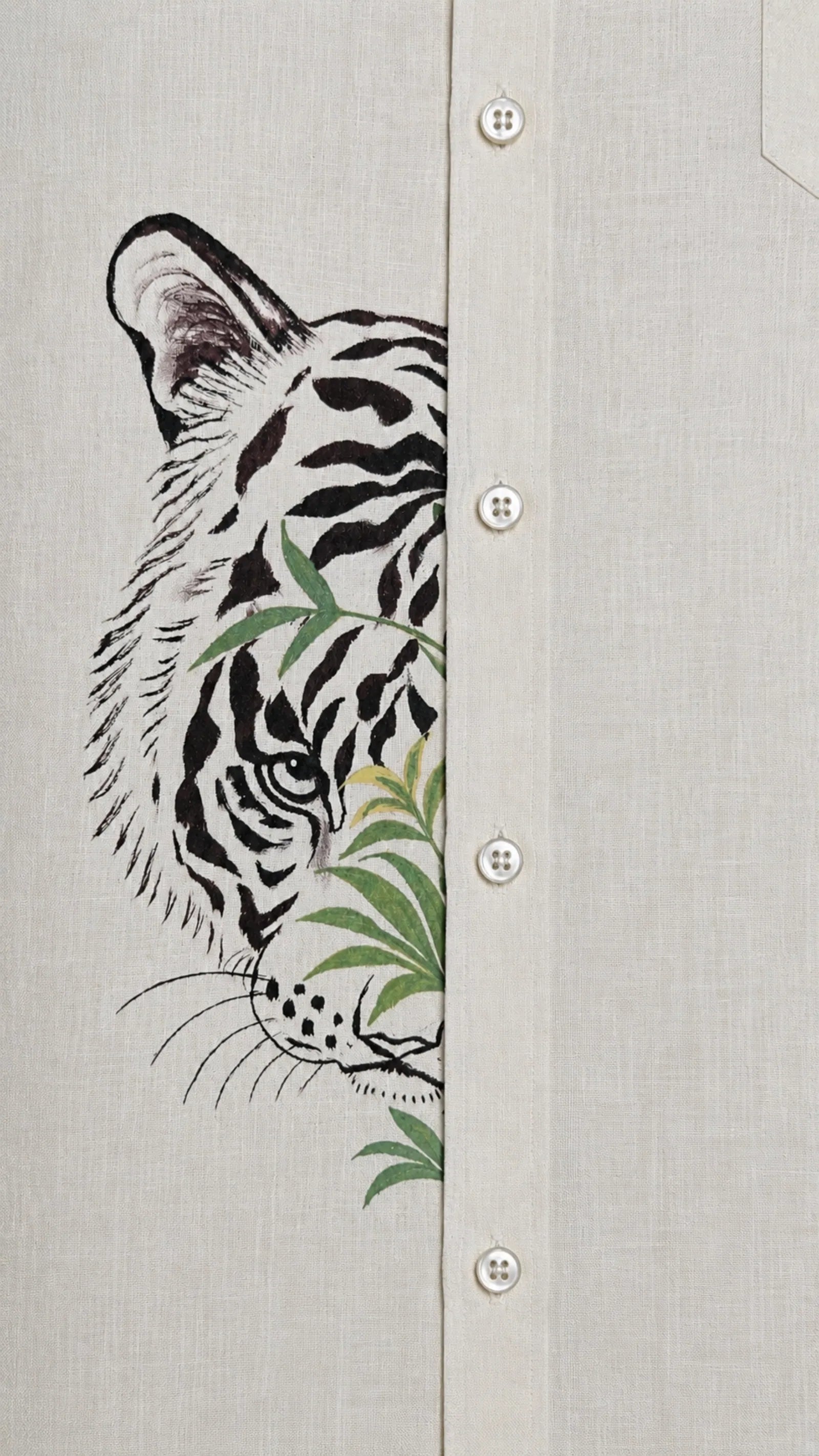 Close-up of tiger artwork crossing the front placket of the Padchinh hand-painted linen shirt on natural linen fabric.