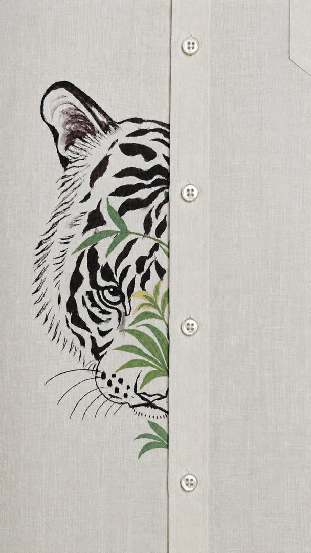 Close-up of tiger artwork crossing the front placket of the Padchinh hand-painted linen shirt on natural linen fabric.