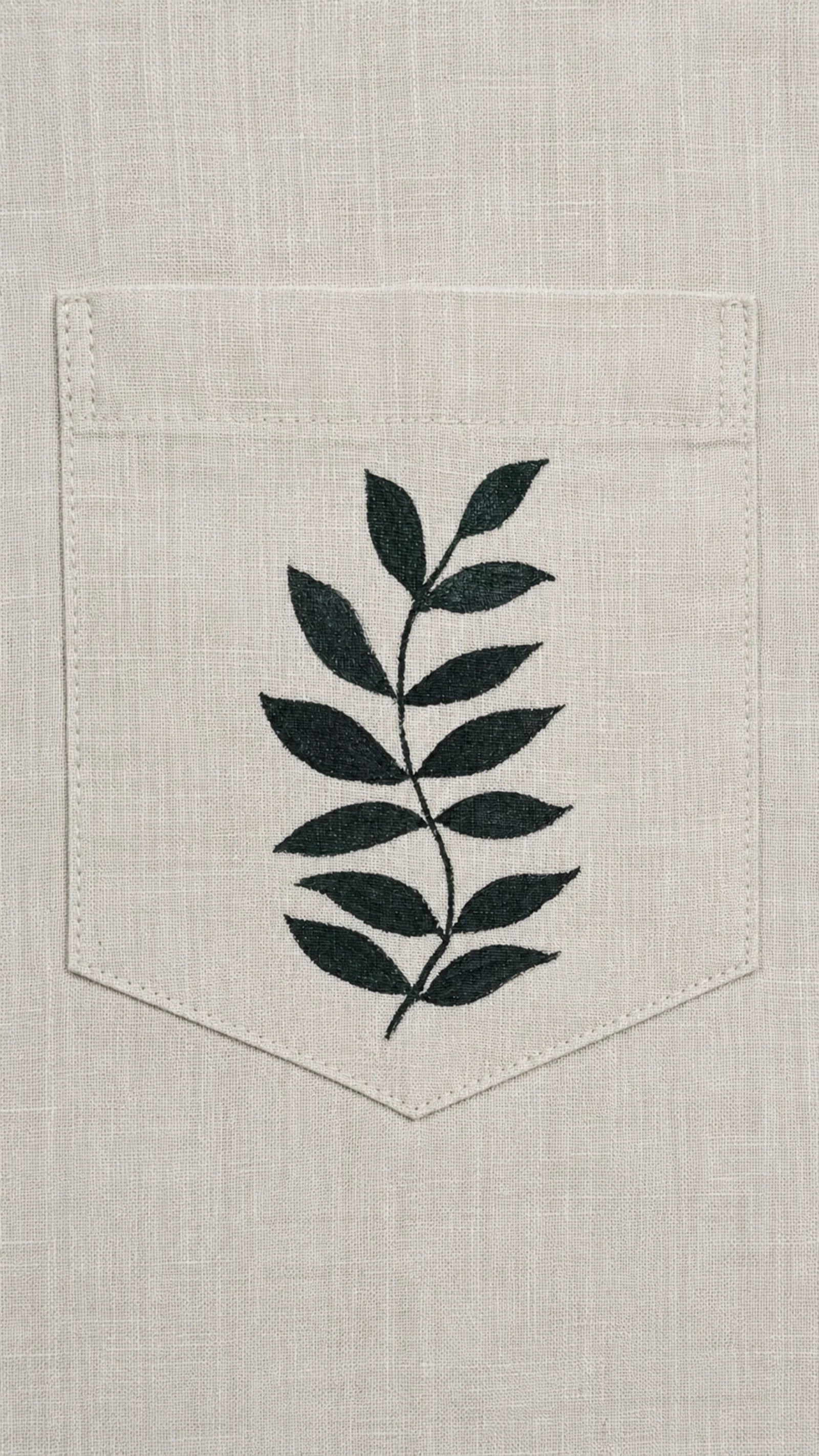 Botanical artwork detail above the pocket of the Padchinh hand-painted linen shirt, revealing the brushwork and fine line detailing of the original artwork.