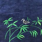 Bottom left artwork detail from the Vanantara hand-painted linen shirt featuring a bird positioned across branching bamboo forms, showcasing the brushwork, composition and fine detailing of the original artwork.