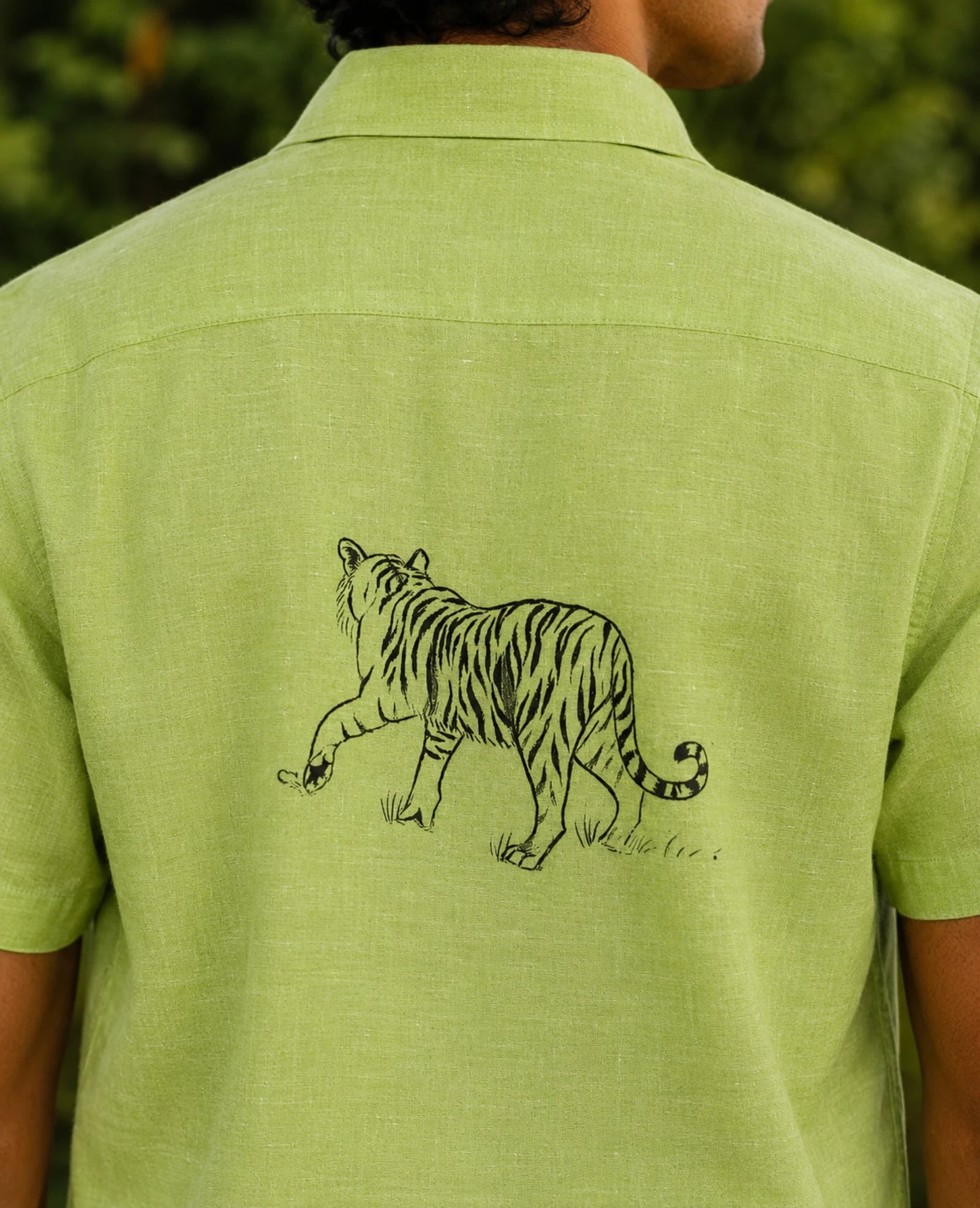 Back detail of the Vanchar hand-painted linen shirt featuring a walking tiger artwork across the upper back.